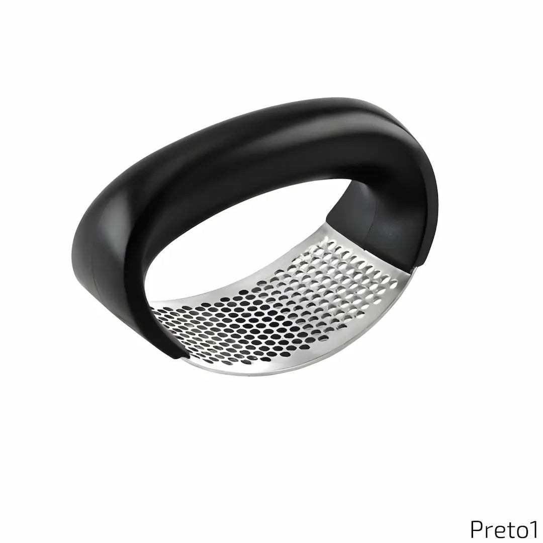 A imagem apresenta um amassador de alho com cabo curvado na cor preta e uma superfície metálica perfurada para triturar alimentos. O design é ergonômico e funcional, adequado para uso prático no preparo de temperos. No canto inferior direito, aparece o texto "Preto1".