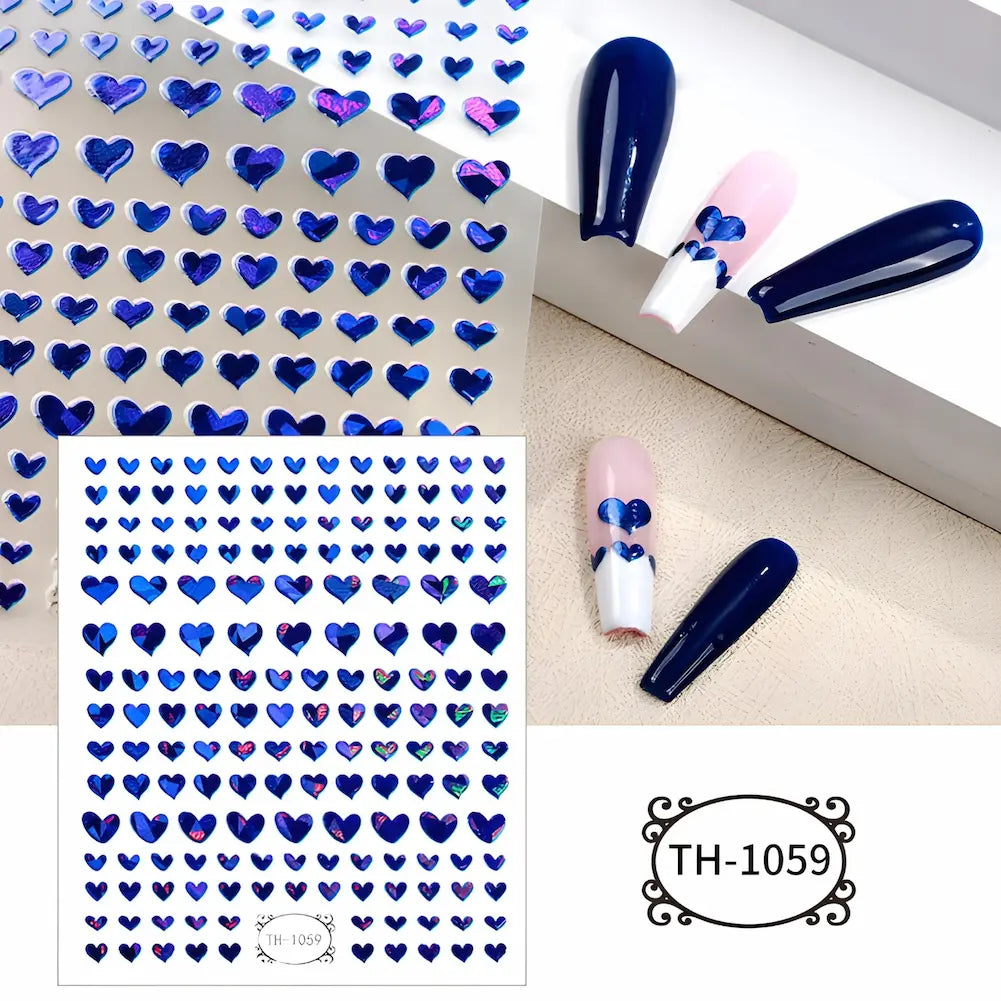 Adesivos de unhas com pequenos corações azuis metálicos. A imagem mostra a aplicação dos corações em unhas com esmalte azul e rosa. Código: TH-1059.