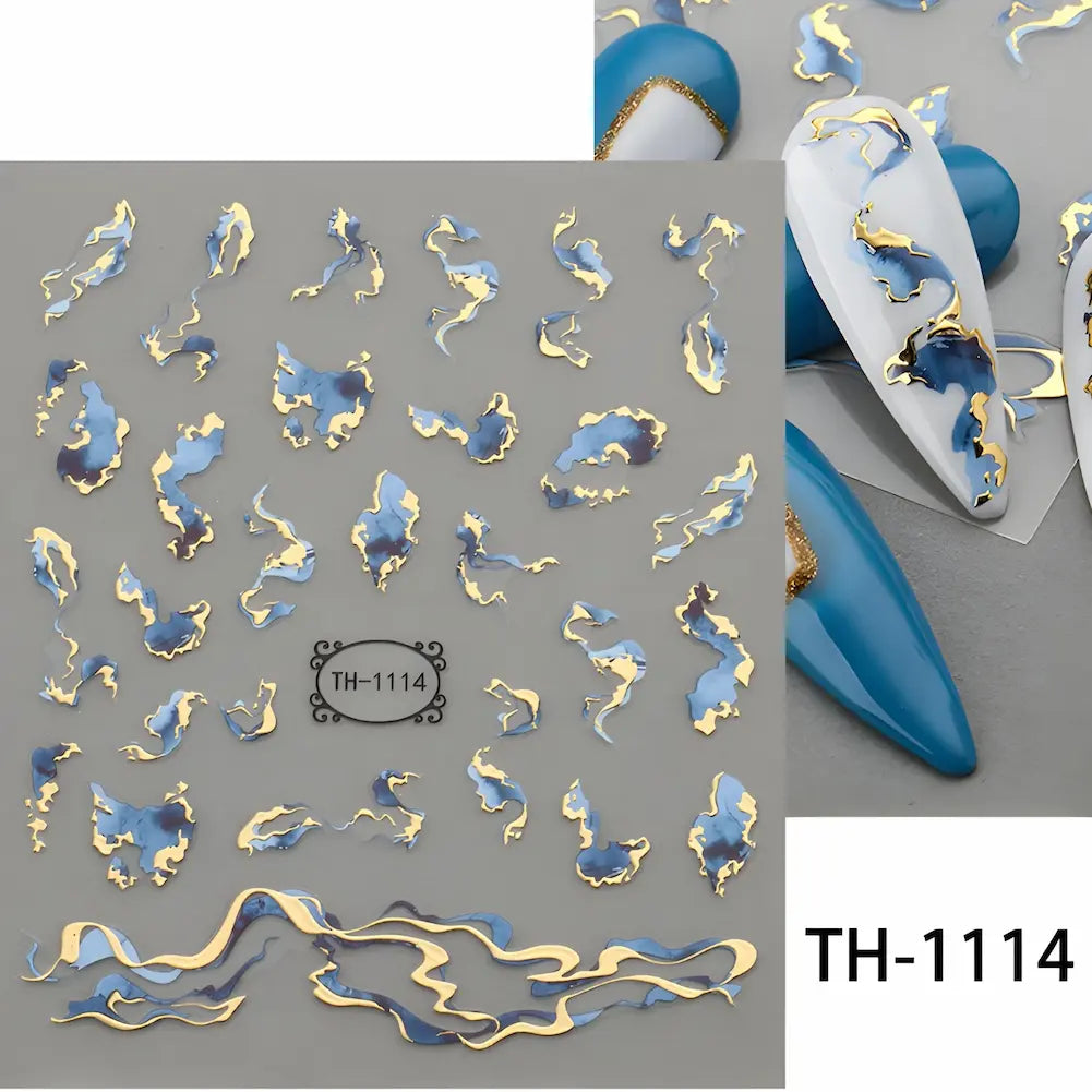 TH-1114: Adesivos com formas abstratas em azul e dourado. As unhas decoradas têm um visual sofisticado e dinâmico com detalhes azuis e dourados.