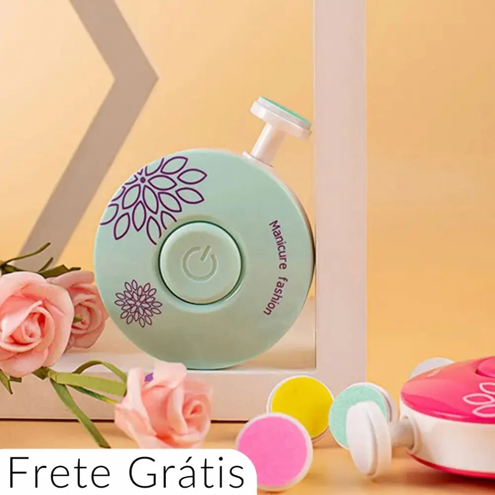 A imagem exibe um cortador de unhas elétrico verde com detalhes florais roxos e um botão central de ligar/desligar. O cortador está posicionado próximo a flores rosas e outras cabeças intercambiáveis coloridas. No canto inferior esquerdo, há um texto "Frete Grátis".