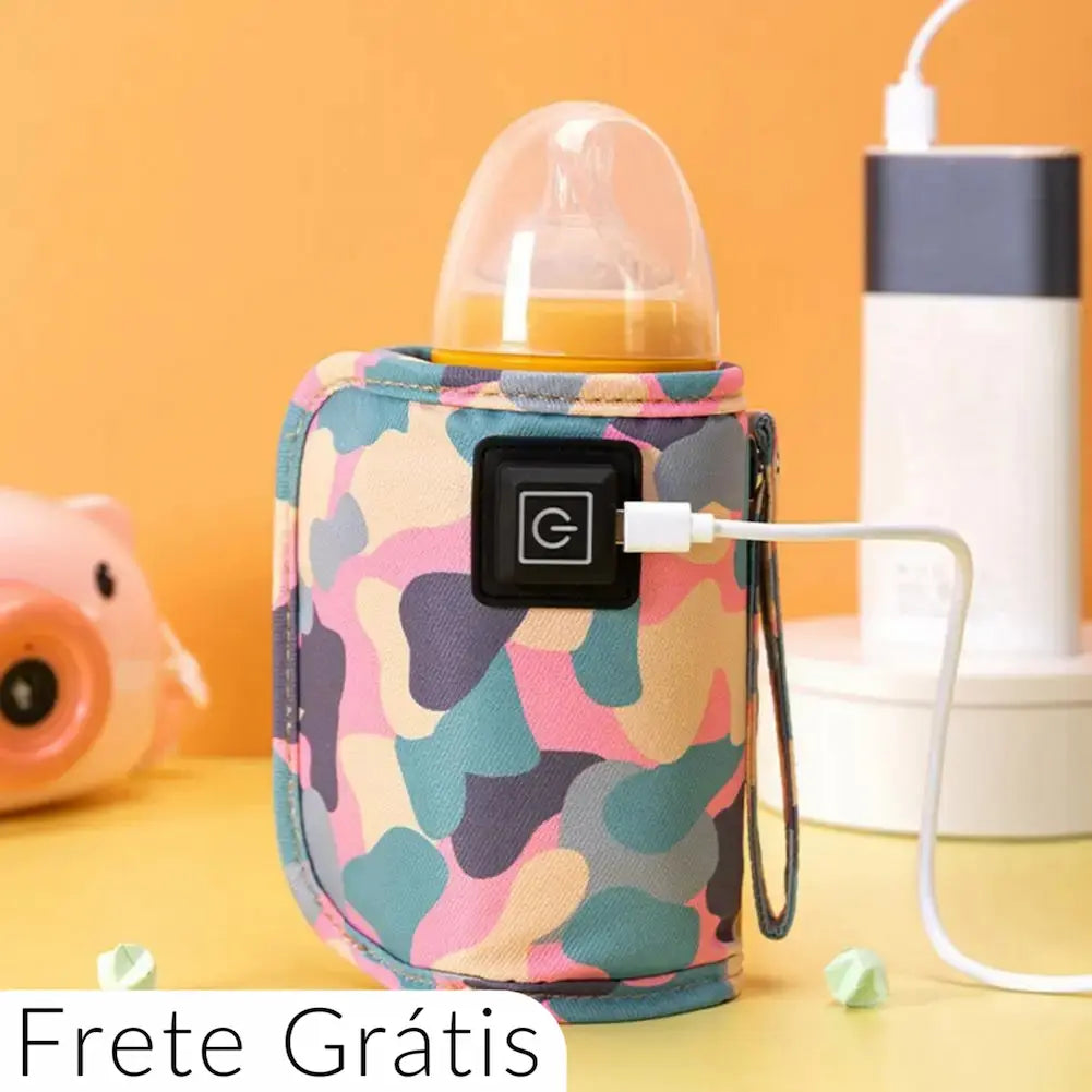 A imagem mostra um aquecedor de mamadeiras USB com um design camuflado colorido em tons de rosa, azul e roxo. O aquecedor está conectado a um cabo USB e contém uma mamadeira. No fundo laranja, há um power bank conectado e um objeto rosa em forma de porquinho à esquerda. Na parte inferior esquerda, há um texto que diz "Frete Grátis".