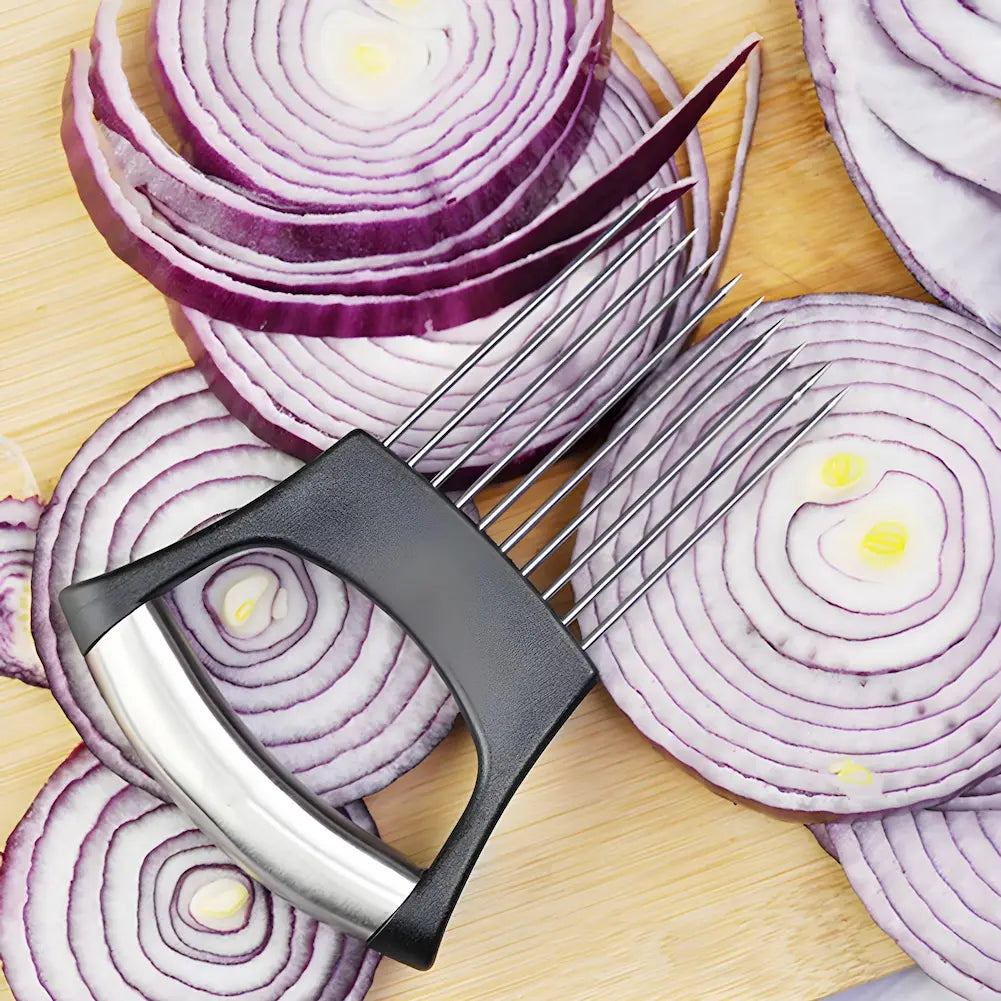 
A imagem mostra um cortador de cebola com lâminas metálicas finas, fixadas a um cabo ergonômico de plástico preto e metal. O cortador está em cima de fatias de cebola roxa, com as camadas visíveis. A tábua de corte de madeira é o fundo da imagem, destacando a ferramenta e a cebola fatiada.