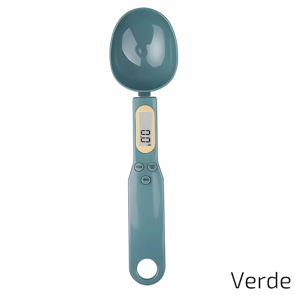 Uma balança digital de precisão em formato de colher, na cor verde. Possui um visor digital com detalhes em amarelo. Abaixo do visor, há três botões: MODE, TARE e HOLD. A colher é grande, ideal para medir ingredientes com precisão.