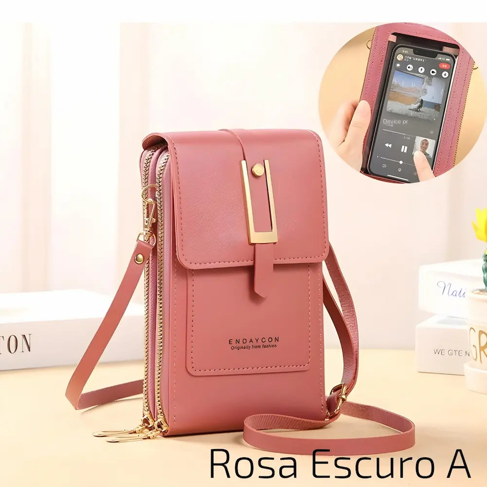Bolsa pequena de couro rosa escuro, com alça ajustável e fecho metálico dourado. Possui dois zíperes laterais e um bolso frontal com o nome "ENDAYCON". No canto inferior direito, o código "Rosa Escuro A", uma das opções de compra.
