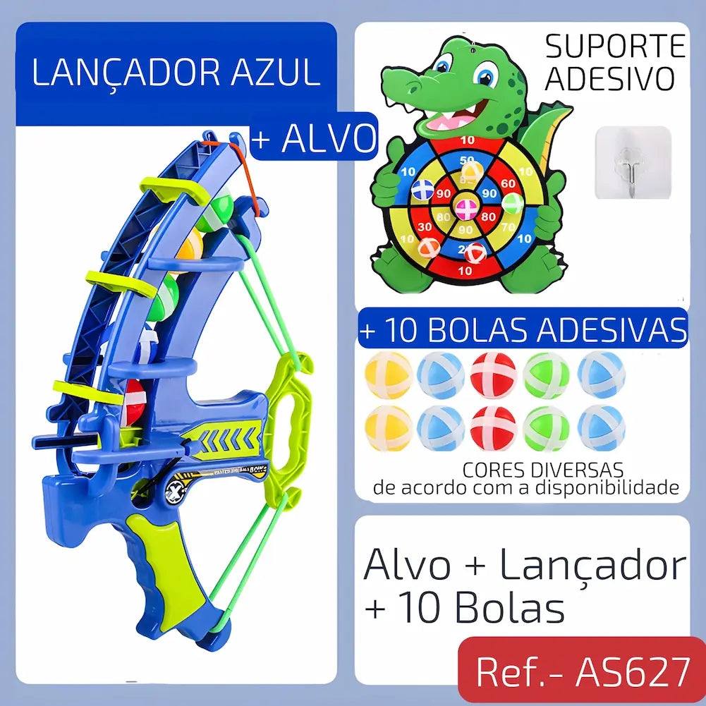 Ref. AS627 Imagem mostrando um lançador azul com alça verde, acompanhado de um alvo de dinossauro e 10 bolas adesivas coloridas. Inclui suporte adesivo para fixação.