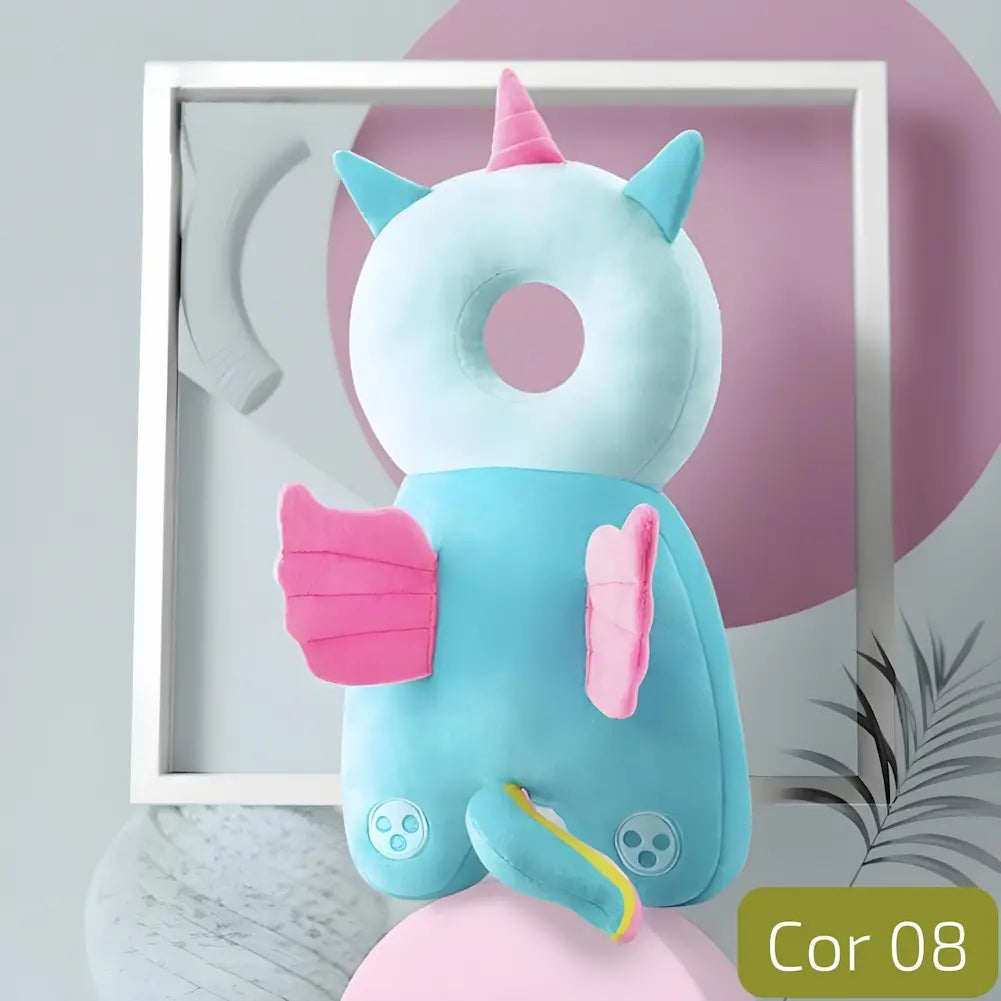  A imagem mostra uma almofada anti-queda para bebês em formato de unicórnio. A almofada é azul clara com detalhes em rosa, incluindo o chifre, asas e cauda. Possui um buraco central para proteger a cabeça do bebê. O cenário de fundo é moderno, com formas geométricas em tons pastel de rosa e cinza, criando uma atmosfera suave e acolhedora. No canto inferior direito, há a indicação "Cor 08".