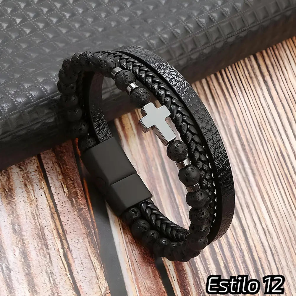 Pulseira preta composta por couro trançado, tiras texturizadas e contas escuras. Destaca-se por um pequeno crucifixo metálico. Fecho preto. Estilo: 12.