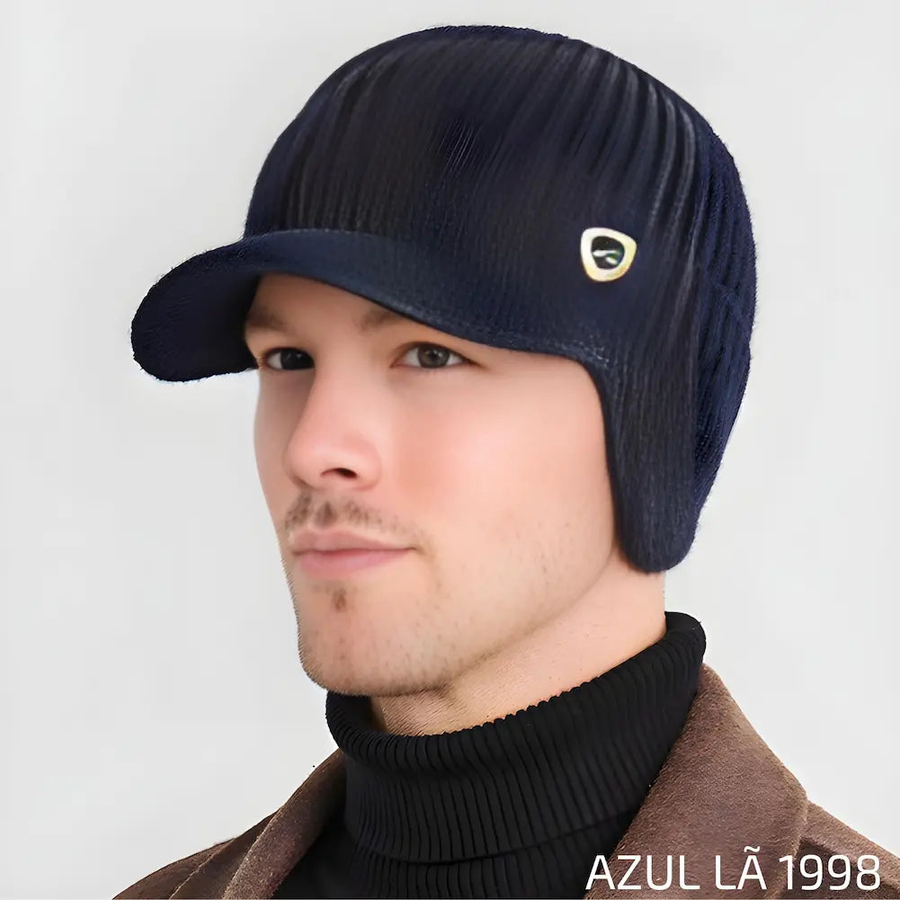 Homem usando um chapéu de lã na cor azul com aba e emblema dourado pequeno, identificado com "1998". Este é uma das opções de compra.