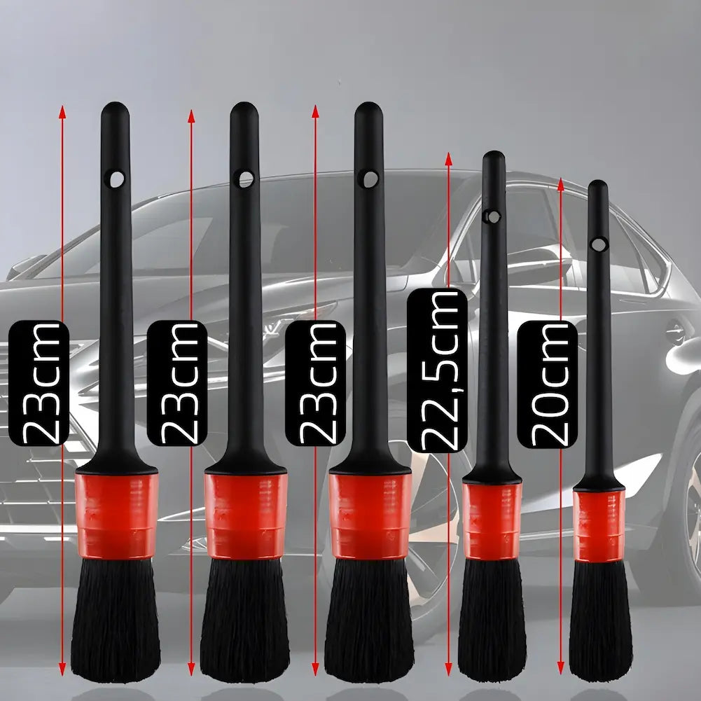 Imagem mostrando cinco pincéis de limpeza automotiva de diferentes tamanhos, dispostos em frente a um carro cinza. As medidas dos pincéis são 23 cm, 23 cm, 23 cm, 22,5 cm e 20 cm, destacadas com setas vermelhas indicando a altura. Cada pincel possui cerdas pretas e cabos pretos com uma faixa vermelha.