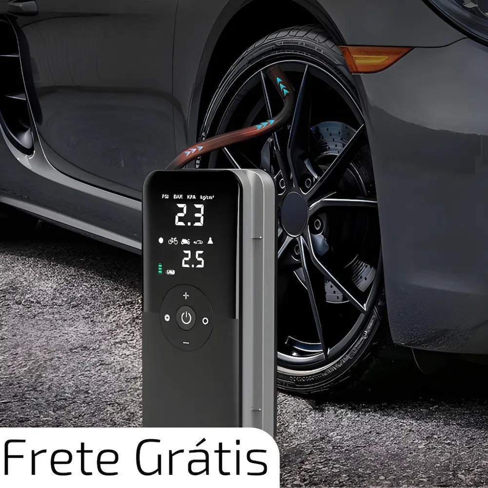 A imagem mostra um inflador de pneus portátil conectado à válvula de um pneu de carro preto. O visor digital do inflador exibe uma leitura de 2.3 e 2.5 psi. O texto "Frete Grátis" está destacado na parte inferior da imagem, indicando uma promoção.