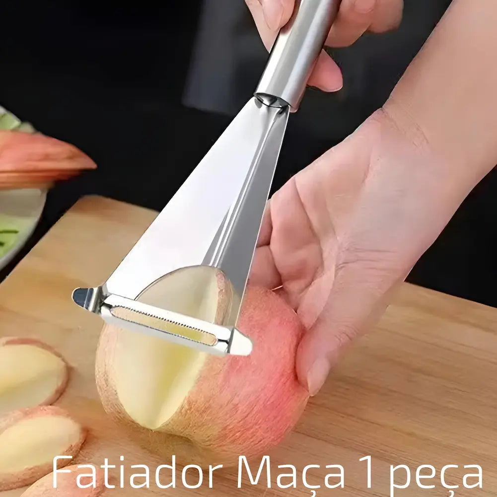  A imagem mostra uma mão usando um fatiador de maçã de metal para cortar fatias finas de uma maçã vermelha. O fatiador tem uma lâmina larga e curva que corta a maçã com precisão. No fundo, há fatias de maçã dispostas em uma tábua de madeira. Na parte inferior, o texto diz "Fatiador Maçã 1 peça".