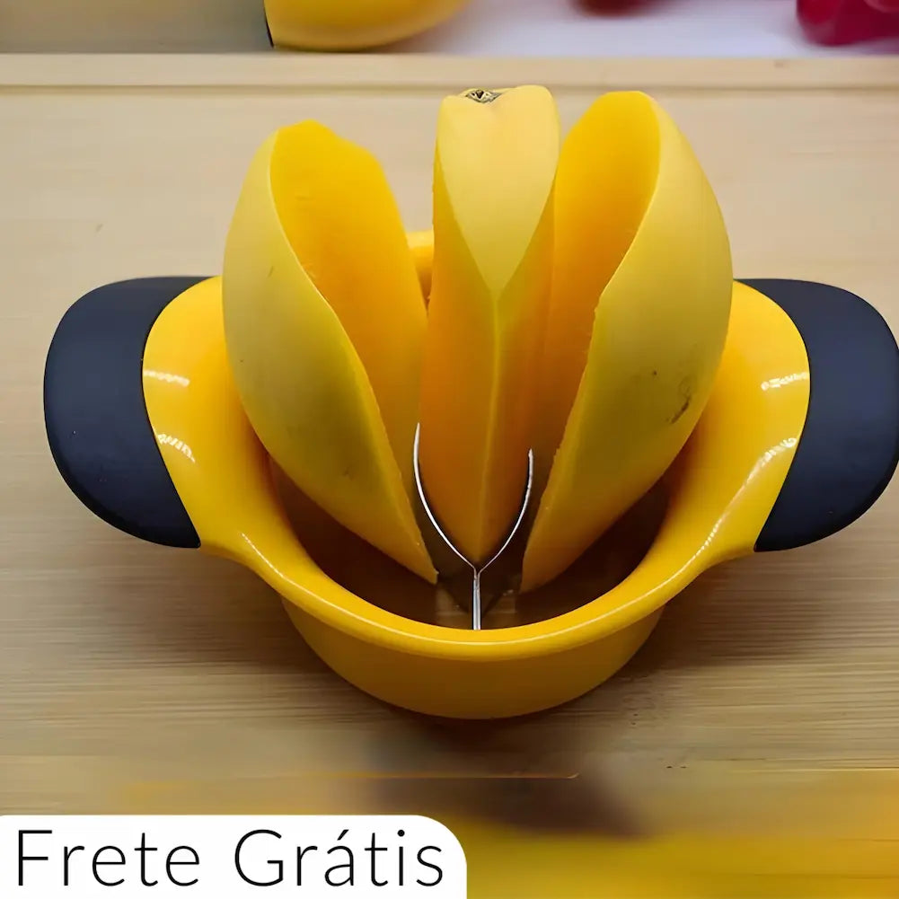 A imagem mostra um descascador de frutas amarelo com alças pretas, cortando uma manga em quatro partes. As fatias da manga estão separadas e erguidas pelo descascador, que tem uma lâmina curva de metal no centro. No canto inferior esquerdo, há o texto "Frete Grátis".