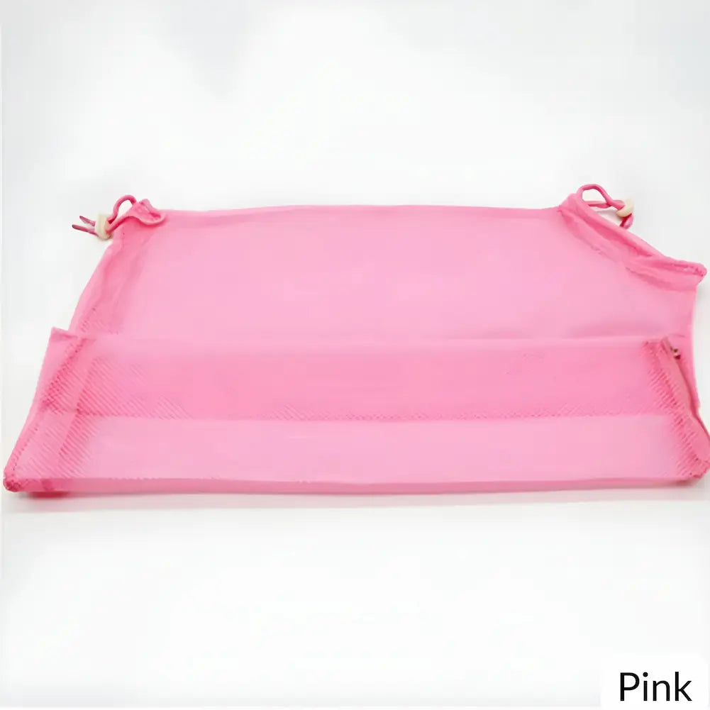  A imagem mostra uma bolsa de rede rosa, desenhada para banho de gatos, estendida sobre uma superfície branca. A bolsa possui cordões ajustáveis na parte superior e um zíper na parte inferior. A palavra "Pink" está escrita no canto inferior direito da imagem em um fundo branco.