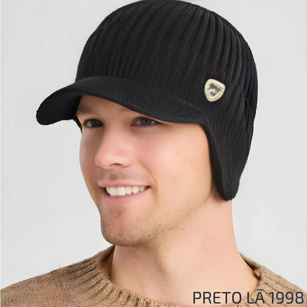 Homem usando um chapéu de lã na cor preta com aba e emblema dourado pequeno, identificado com "1998". Este é uma das opções de compra.