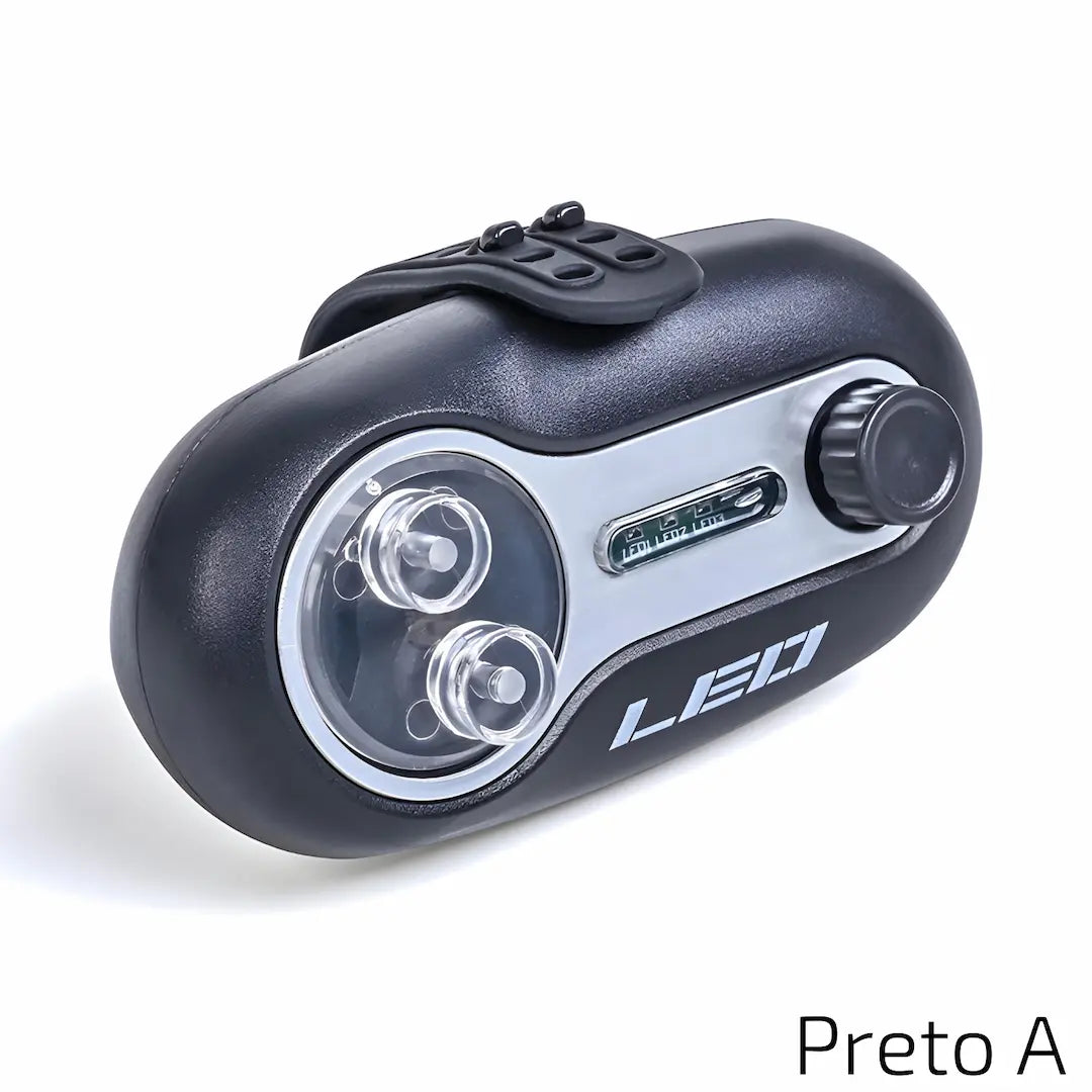 A imagem mostra um dispositivo preto com detalhes em prata, com um design compacto. Ele possui duas lâmpadas de LED visíveis, além de um botão de ajuste e uma tela de controle. A palavra "LED" está claramente marcada na parte frontal do dispositivo, indicando sua funcionalidade relacionada à luz.