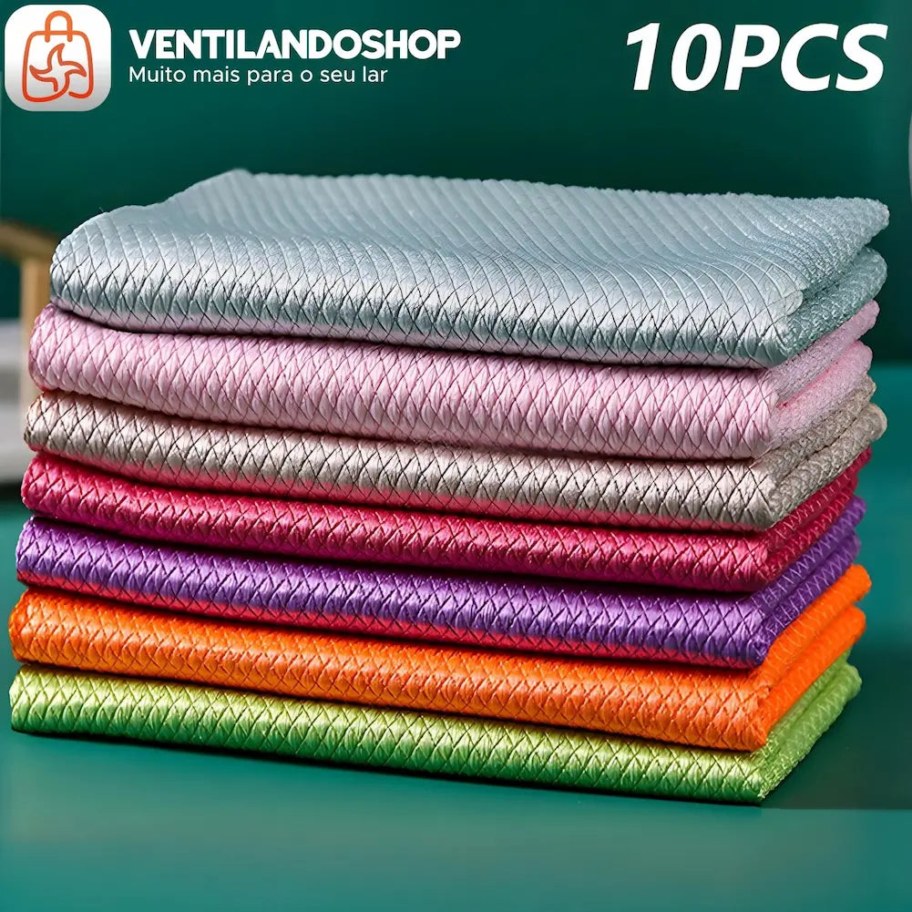 A imagem mostra uma pilha de dez flanelas de microfibra dobradas em várias cores. De cima para baixo, as cores são: cinza, rosa claro, cinza claro, rosa escuro, roxo, laranja e verde. No canto superior esquerdo, há um logotipo e o texto "VENTILANDOSHOP Muito mais para o seu lar". No canto superior direito, está escrito "10PCS". O fundo é verde.