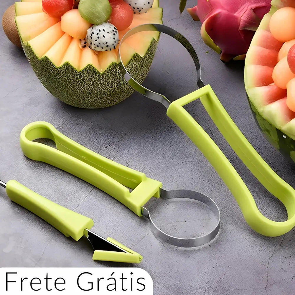  A imagem mostra três utensílios de esculpir frutas com cabos verdes, incluindo uma lâmina circular e uma ponta afiada. Ao redor, há um melão e uma melancia esculpidos, cheios de bolas de frutas coloridas. No canto inferior esquerdo, há o texto "Frete Grátis" sobre um fundo branco.