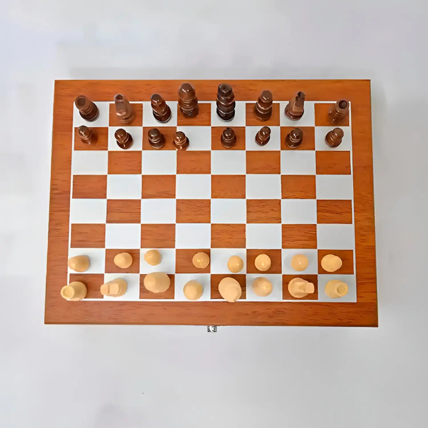 O tabuleiro de xadrez está posicionado de forma que vemos toda a sua superfície. Ele é de madeira, com quadrados claros e escuros alternados. As peças são de madeira, com uma combinação de tons claros e escuros. As peças brancas estão dispostas na linha inferior, com peões à frente e outras peças maiores atrás. As peças pretas estão na linha superior, com uma formação semelhante. A imagem é tirada de cima, proporcionando uma visão clara do tabuleiro e das peças.