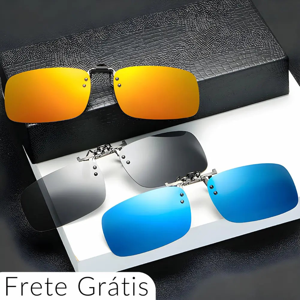 A imagem exibe três lentes solares clip-on para óculos, em diferentes cores: dourado espelhado, cinza escuro e azul espelhado. Elas têm design retangular moderno e são apresentadas em um display elegante com uma caixa texturizada ao fundo. Ideal para quem busca estilo e praticidade.