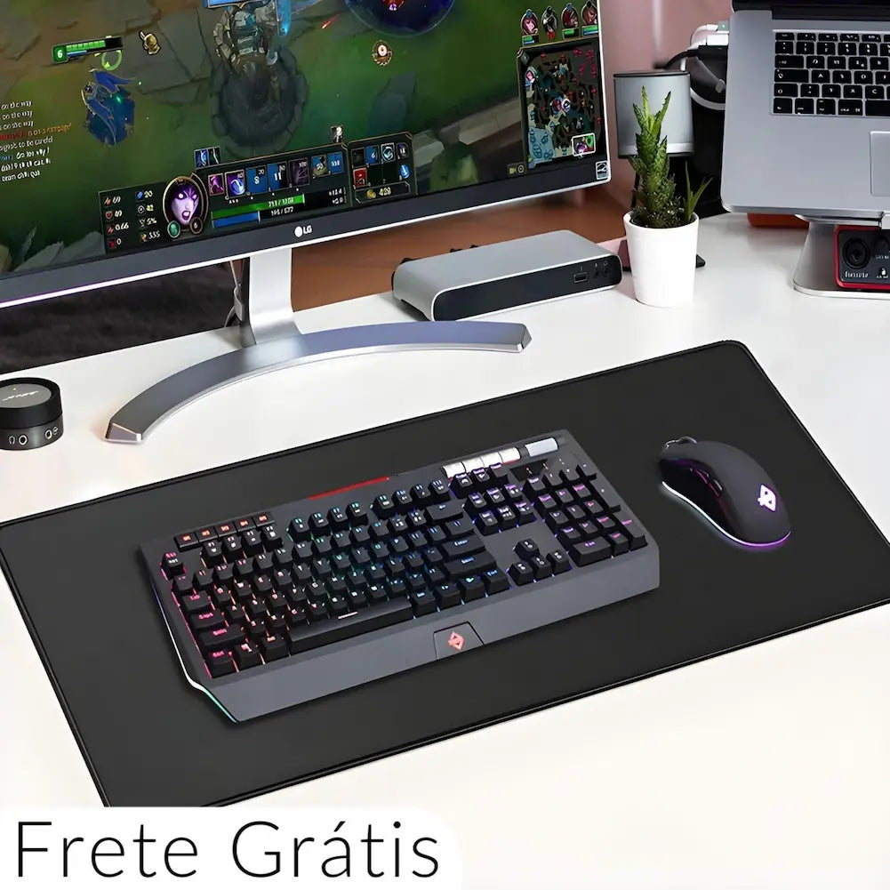  Uma mesa branca com um grande mousepad preto que acomoda um teclado mecânico iluminado e um mouse preto com detalhes luminosos. Ao fundo, um monitor grande exibe um jogo. Há uma planta em vaso branco, um laptop e dispositivos eletrônicos próximos. No canto inferior esquerdo, há o texto "Frete Grátis".