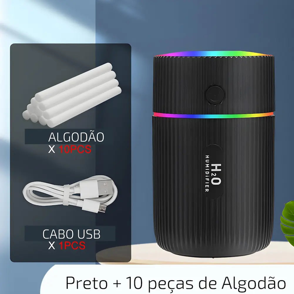 Imagem mostrando um umidificador de ar portátil preto com textura ondulada, emitindo luzes coloridas no topo. Ao lado, há uma representação dos acessórios incluídos: dez peças de algodão cilíndricas e um cabo USB branco. Abaixo dos acessórios, há textos indicando "ALGODÃO X 10PCS" e "CABO USB X 1PCS". Na parte inferior da imagem, lê-se "Preto + 10 peças de Algodão".