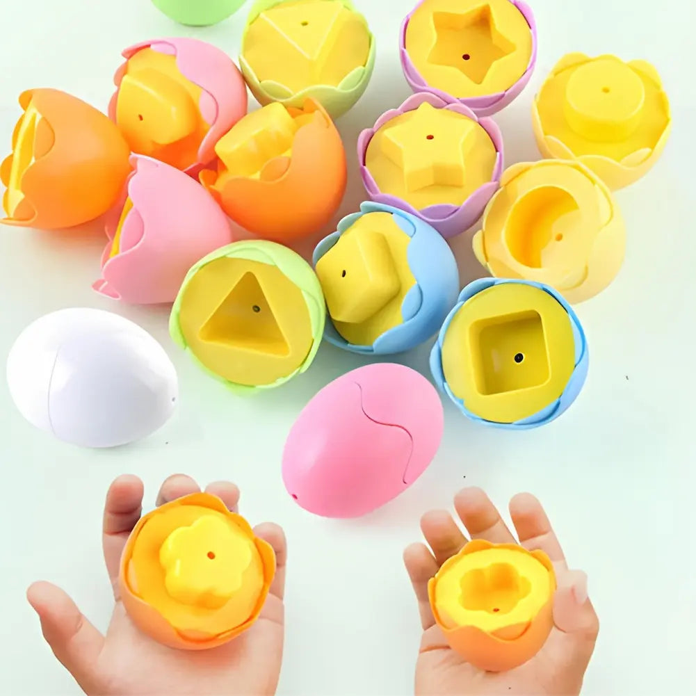 A imagem mostra vários ovos de plástico coloridos abertos, revelando formas geométricas amarelas em seu interior, como estrela, triângulo e quadrado. As cores dos ovos incluem laranja, rosa, verde, azul e roxo. Duas mãos seguram ovos abertos, exibindo as formas internas. O fundo é branco.