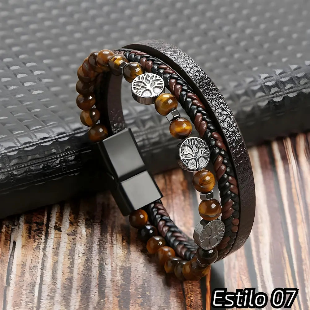 Pulseira marrom e preta com couro trançado e texturizado, adornada com contas marrons e três medalhões metálicos com o símbolo da árvore da vida. Fecho preto, perfeito para um estilo natural e sofisticado. Estilo: 07.
