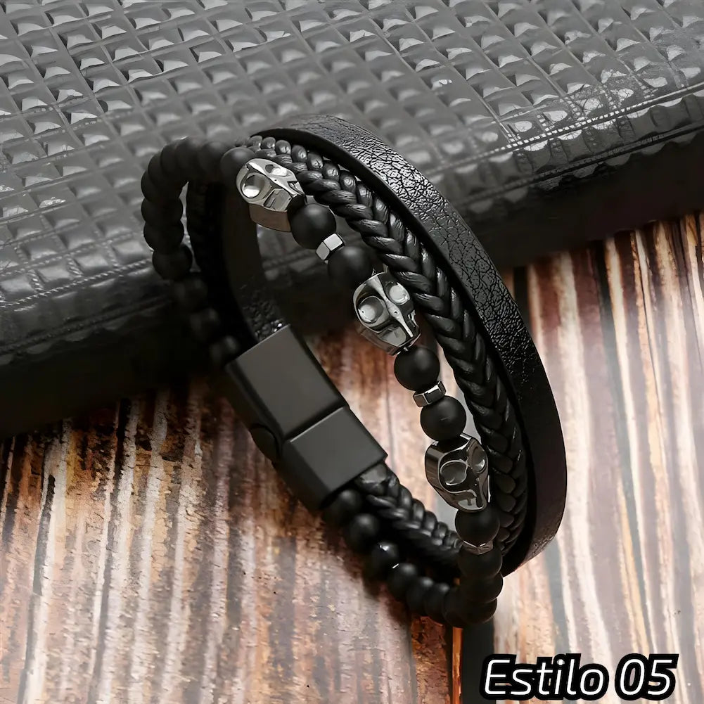 Pulseira preta composta por couro trançado e texturizado, adornada com contas escuras e detalhes metálicos em forma de caveira. Fecho preto, ideal para um estilo moderno e ousado. Estilo: 05.