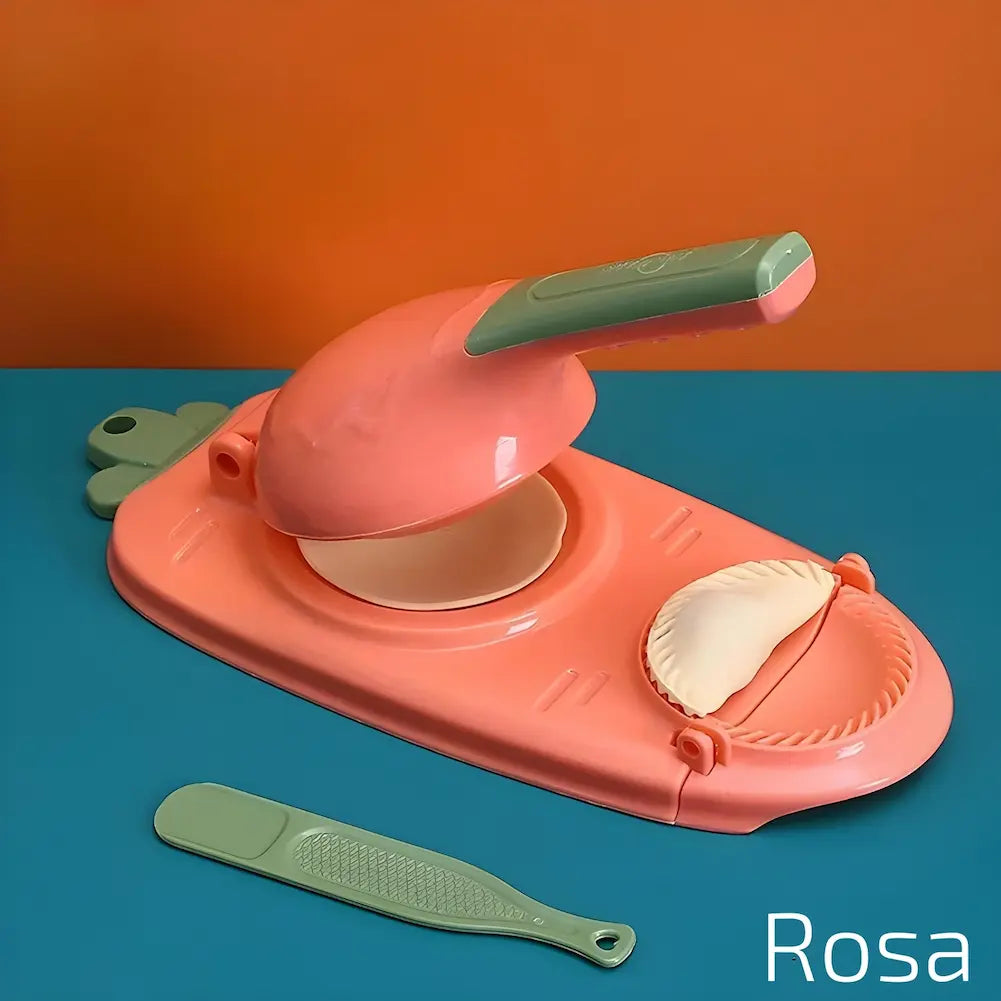  A imagem mostra um modelador manual de dumplings rosa sobre uma superfície azul e uma parede laranja. O aparelho está aberto com um disco de massa no centro e um dumpling moldado ao lado. Há uma espátula verde e um disco de massa adicional ao lado. O texto "Rosa" está na parte inferior direita.