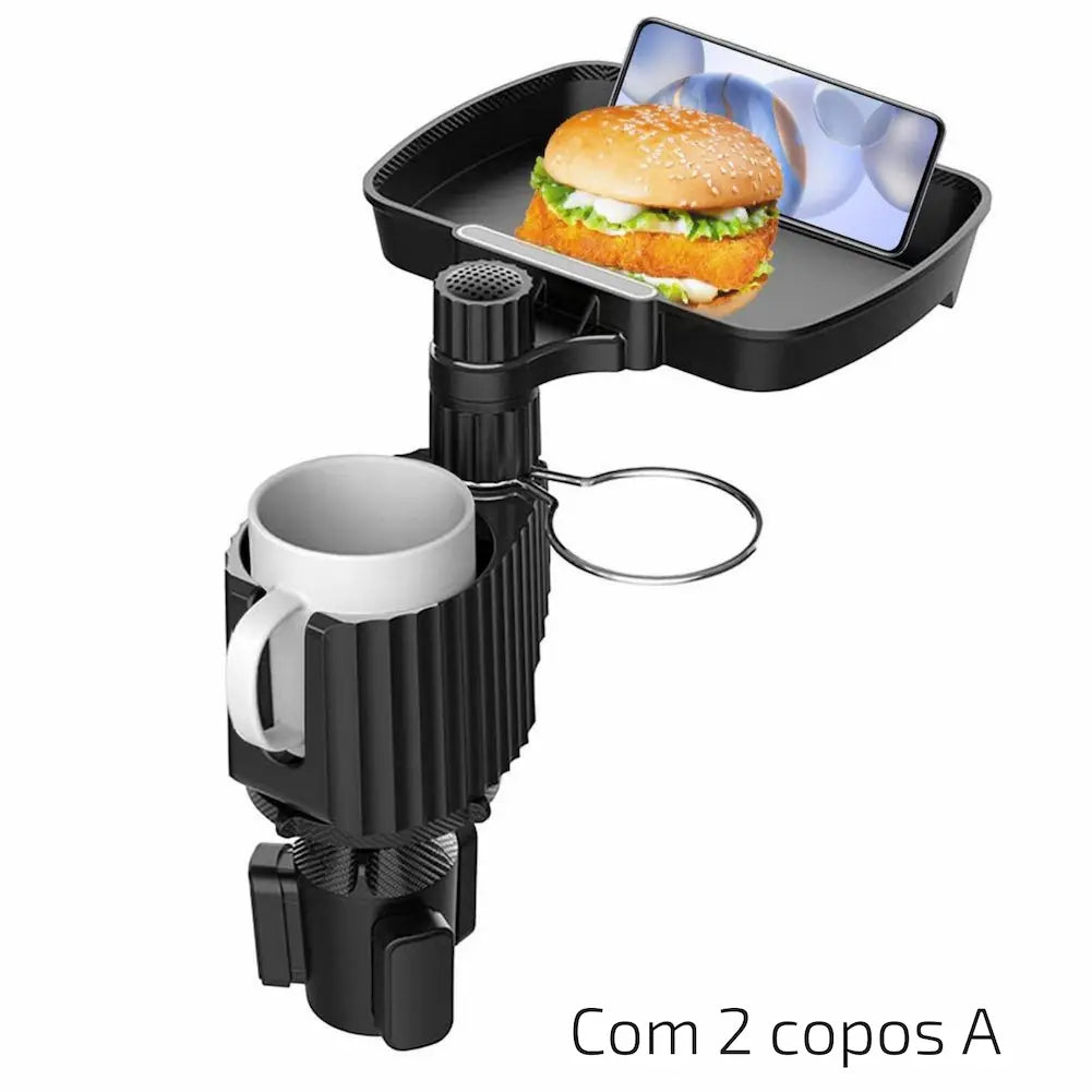 A imagem mostra um suporte giratório com uma bandeja superior contendo um hambúrguer e um celular. Abaixo, há dois suportes: um com uma caneca branca e outro suporte vazio. O suporte é preto e se encaixa no console do carro. Na parte inferior direita, está escrito "Com 2 copos A".