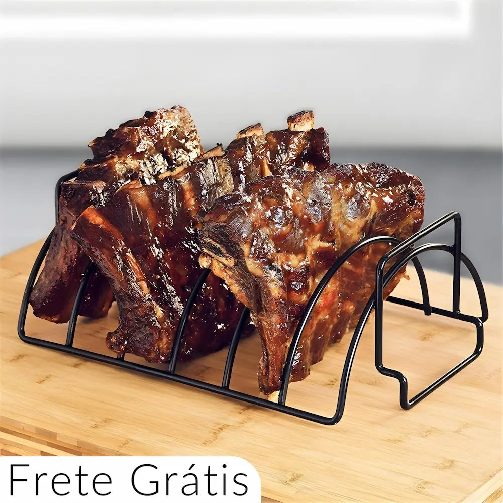 A imagem mostra um suporte de metal para grelhar costelas, colocado sobre uma tábua de madeira. O suporte está carregado com costelas bem grelhadas e caramelizadas, prontas para servir. A estrutura de metal mantém as costelas organizadas e permite uma cocção uniforme. Na parte inferior da imagem, há um texto que diz "Frete Grátis", destacando um benefício adicional para a compra do produto.