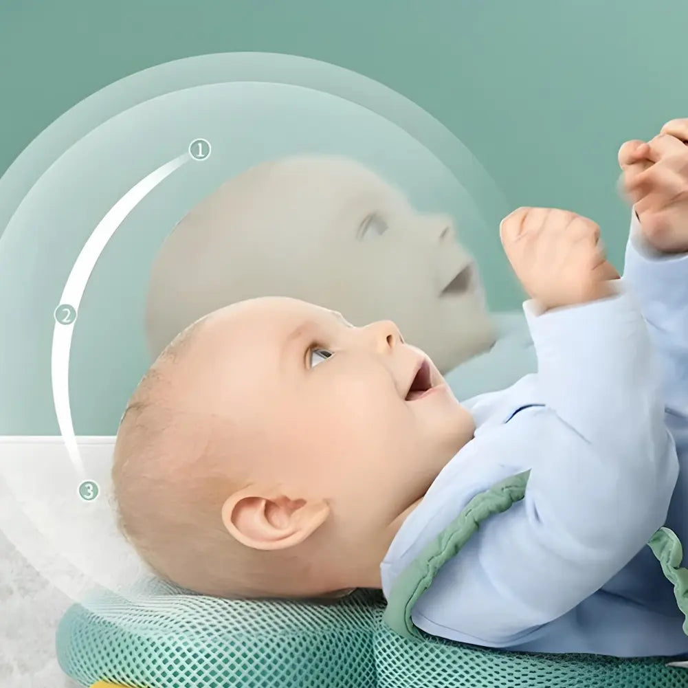  A imagem mostra um bebê deitado de costas, com a cabeça apoiada em um travesseiro de segurança. Há uma ilustração sobreposta mostrando o movimento da cabeça do bebê em três etapas, indicando a proteção proporcionada pelo travesseiro contra impactos. O travesseiro é verde e feito de um material acolchoado que amortece a queda, proporcionando conforto e segurança. O fundo é de cor verde clara, complementando a tranquilidade da cena.